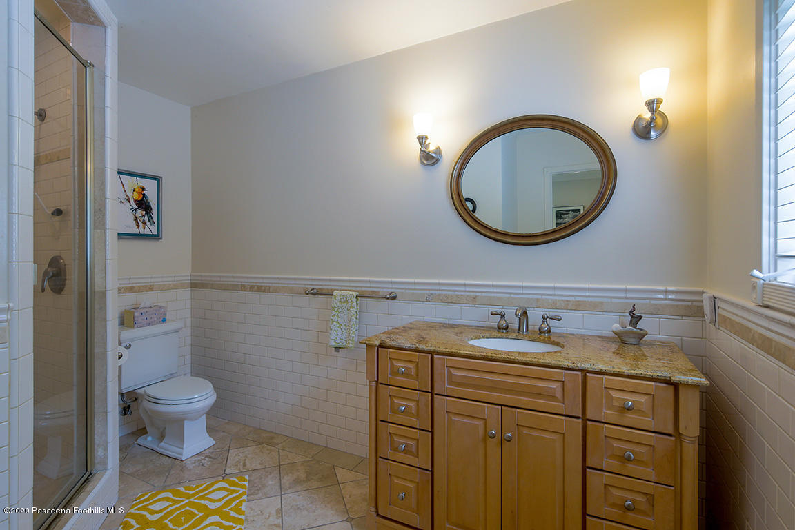 1987 Braeburn Road Altadena, CA 91001 - Photo 22 of 48 a bathroom with a granite countertop toilet a sink and a mirror