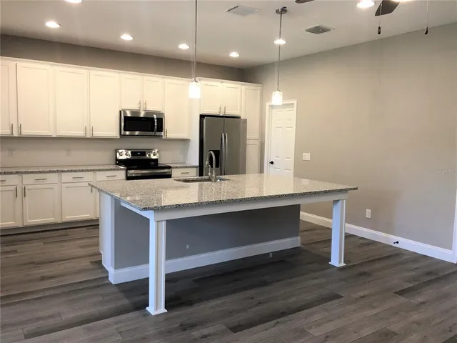 a kitchen with a sink cabinets and wooden floor