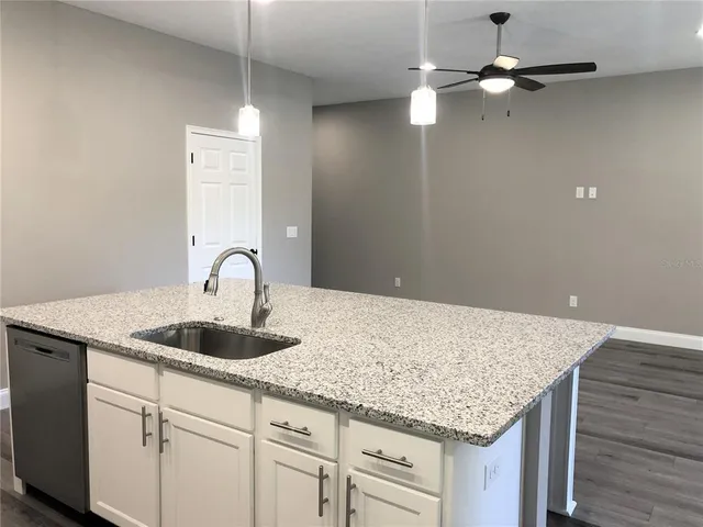 a kitchen with granite countertop cabinets and chandelier