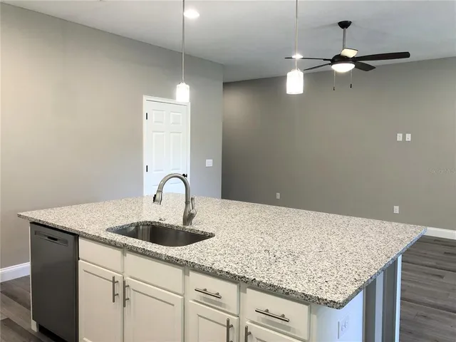 a kitchen with center island with cabinets and wooden floor