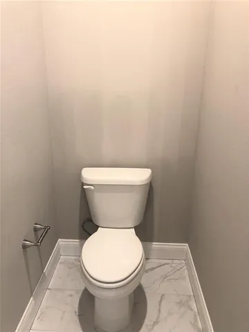 a white toilet sitting next to a white wall