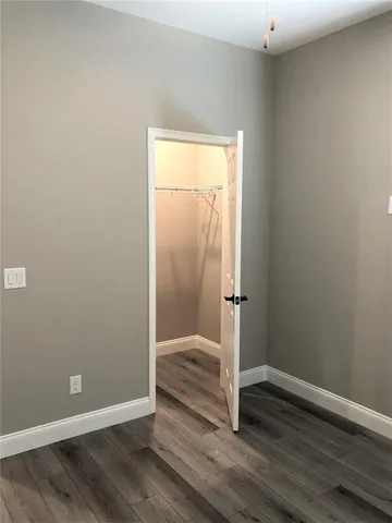an empty room with wooden floor and closet