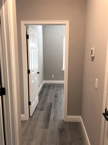 a view of a hallway with wooden floor