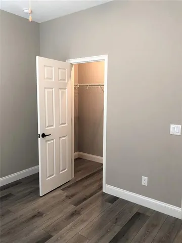 an empty room with wooden floor and mirror