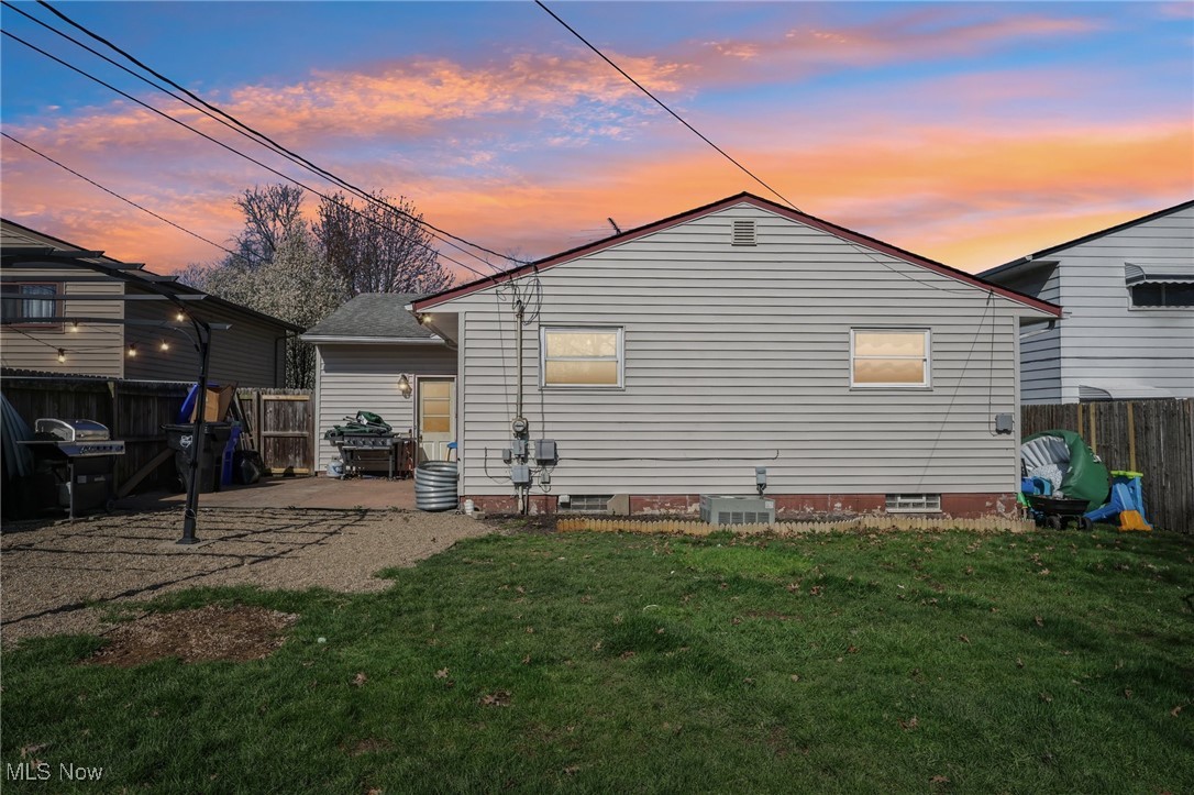6475 Fry Road Brook Park, OH 44142 - Photo 2 of 20 Back of property at dusk featuring a patio area, fence private yard, and a lawn