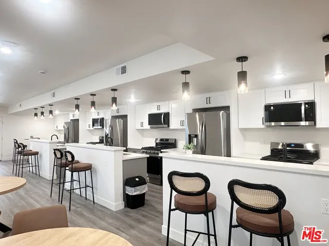 a kitchen with stainless steel appliances kitchen island granite countertop a sink and cabinets