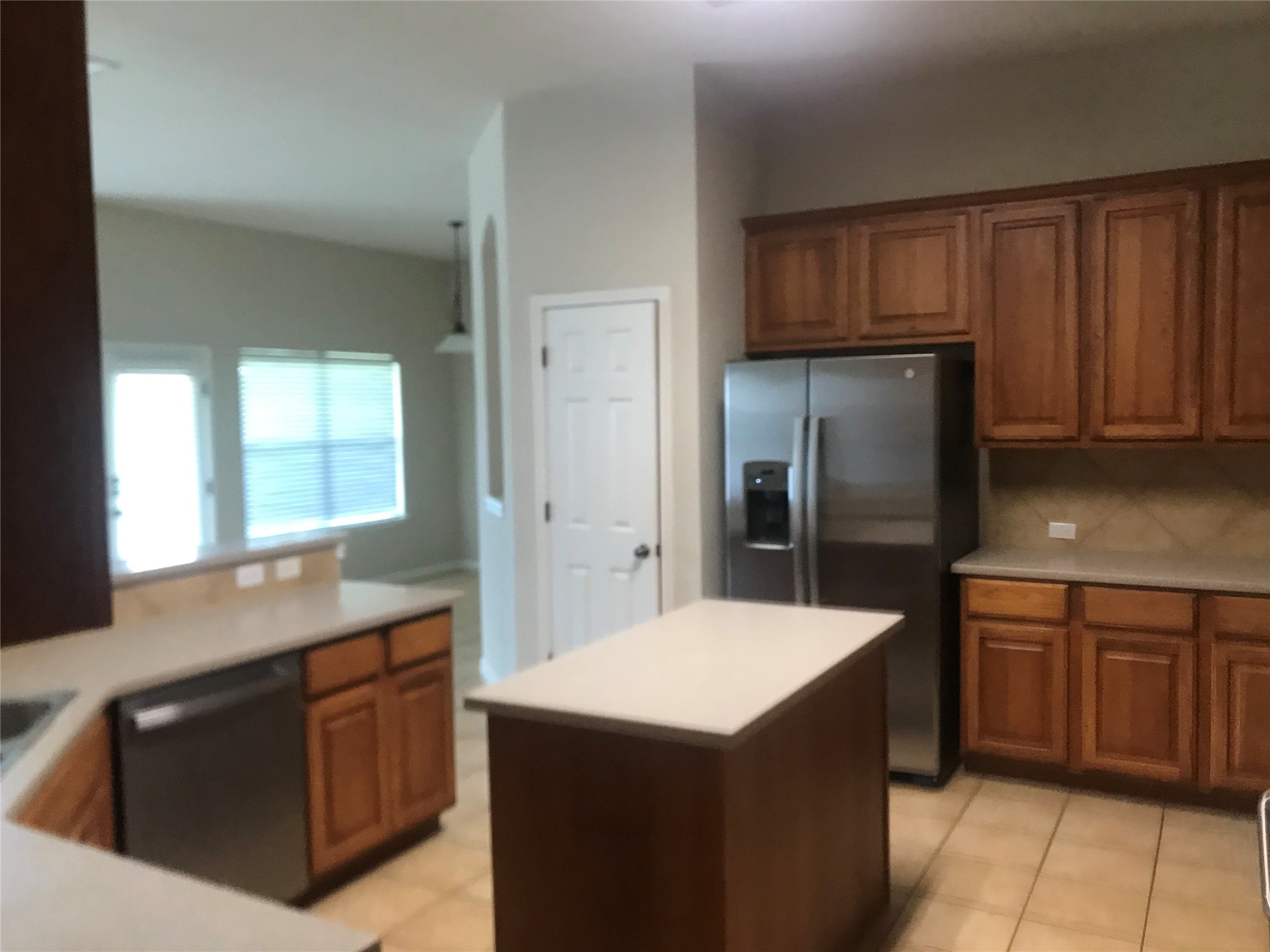 913 Rochester Castle Way Pflugerville, TX 78660 - Photo 10 of 25 A well-appointed kitchen features a central island and warm wood cabinetry with tile flooring.