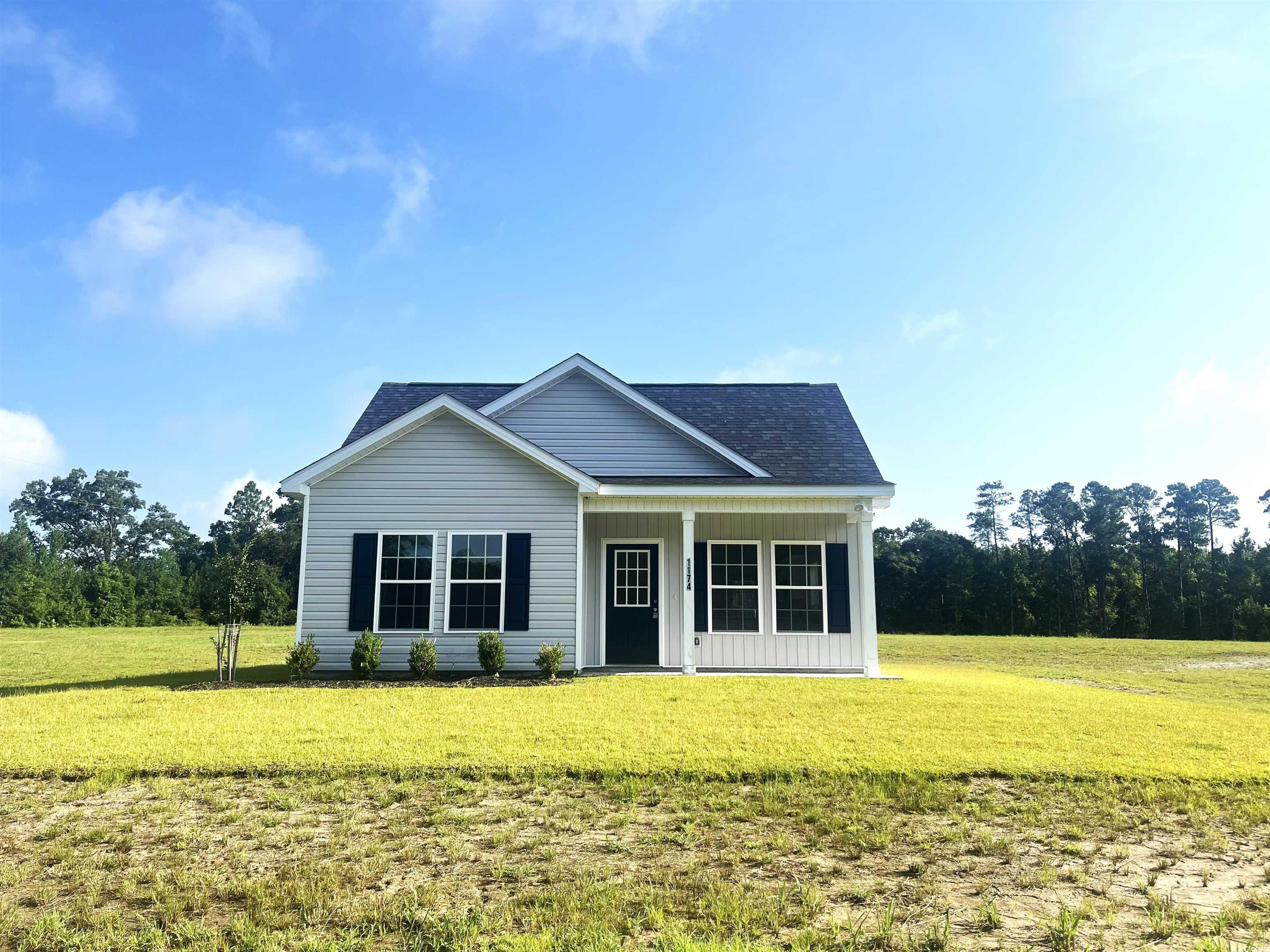 1174 St John Road Galivants Ferry, SC 29544 - Photo 1 of 22 View of front facade featuring a front yard, board and batten siding, a porch, and a shingled roof