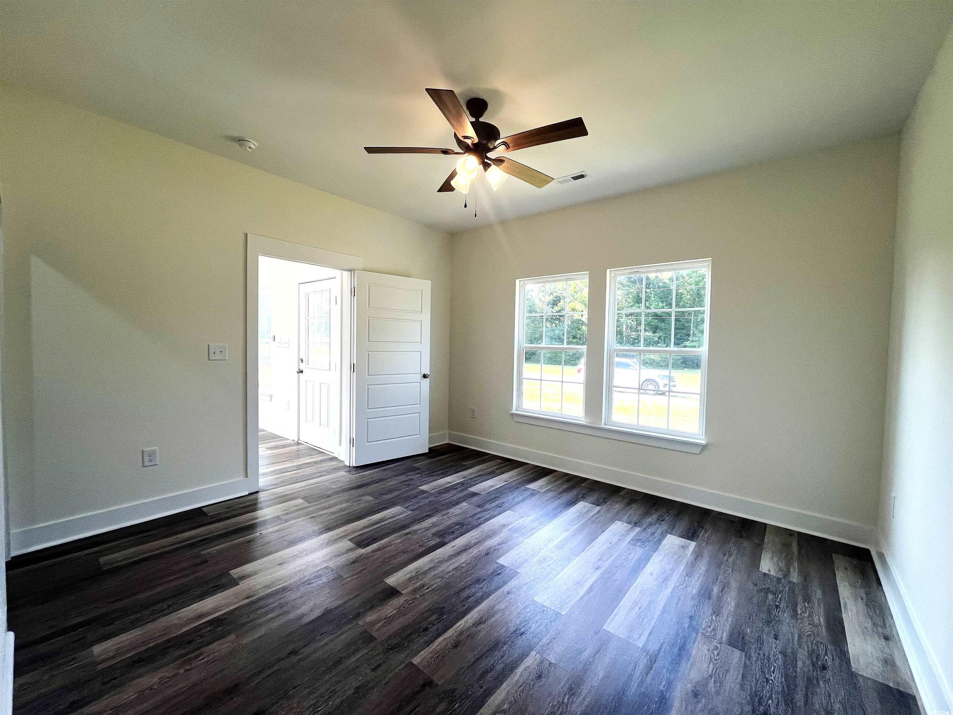 1174 St John Road Galivants Ferry, SC 29544 - Photo 14 of 22 Empty room featuring a ceiling fan, dark wood-style flooring, and a smoke detector