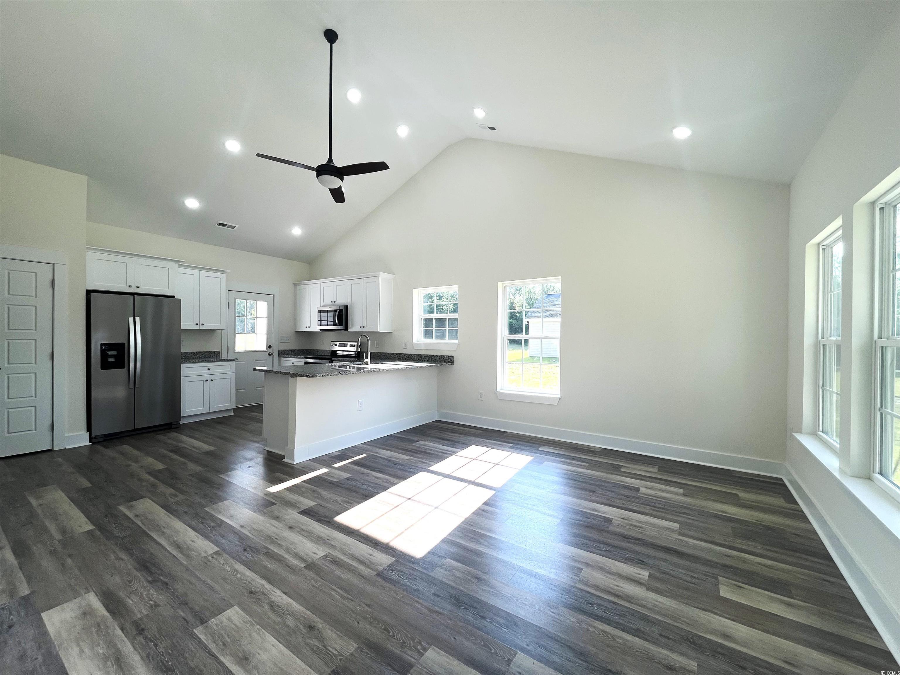 1174 St John Road Galivants Ferry, SC 29544 - Photo 5 of 22 Kitchen with stainless steel appliances, ceiling fan, a peninsula, white cabinets, and dark countertops