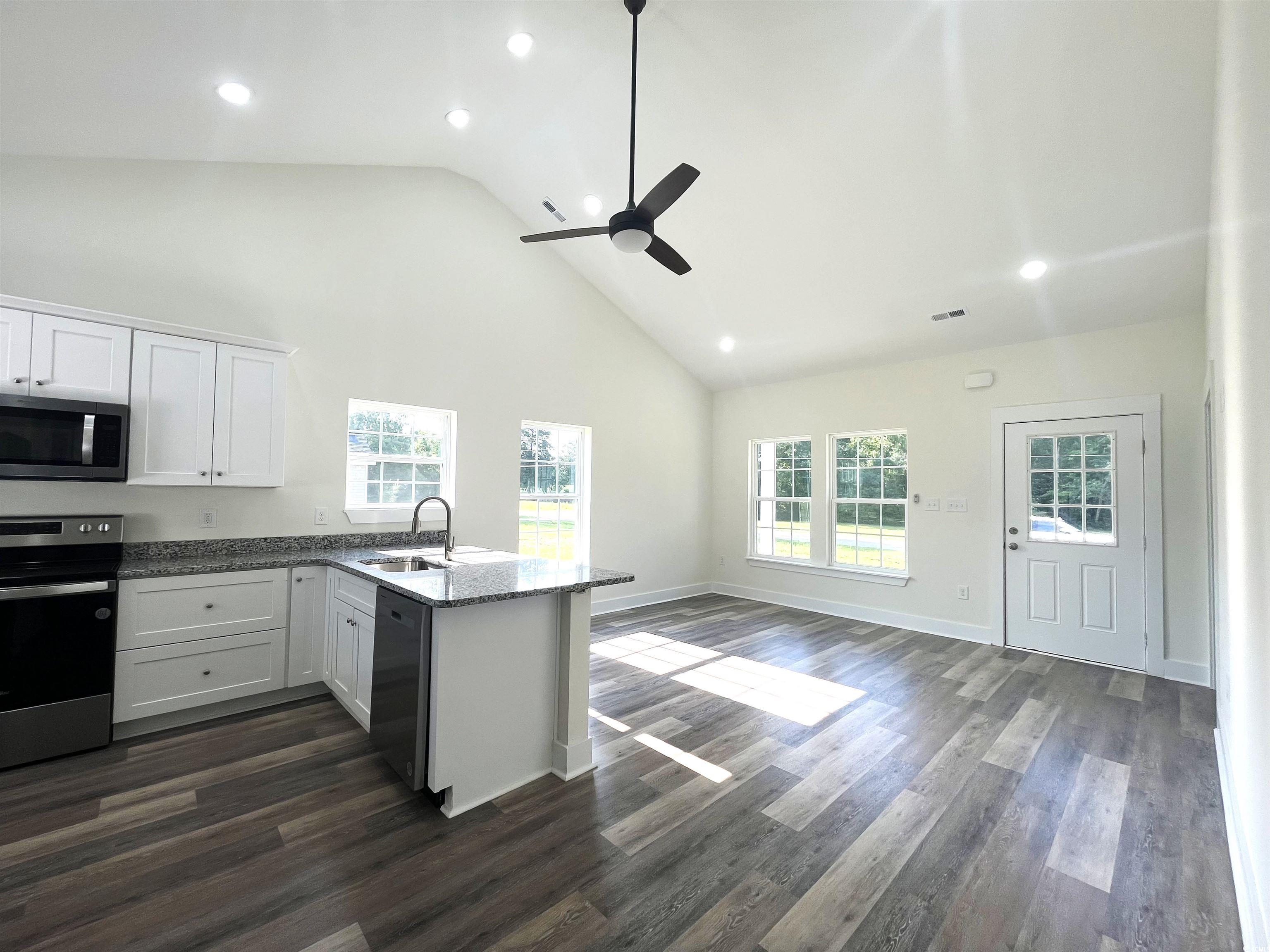 1174 St John Road Galivants Ferry, SC 29544 - Photo 7 of 22 Kitchen with appliances with stainless steel finishes, high vaulted ceiling, white cabinets, ceiling fan, and a peninsula