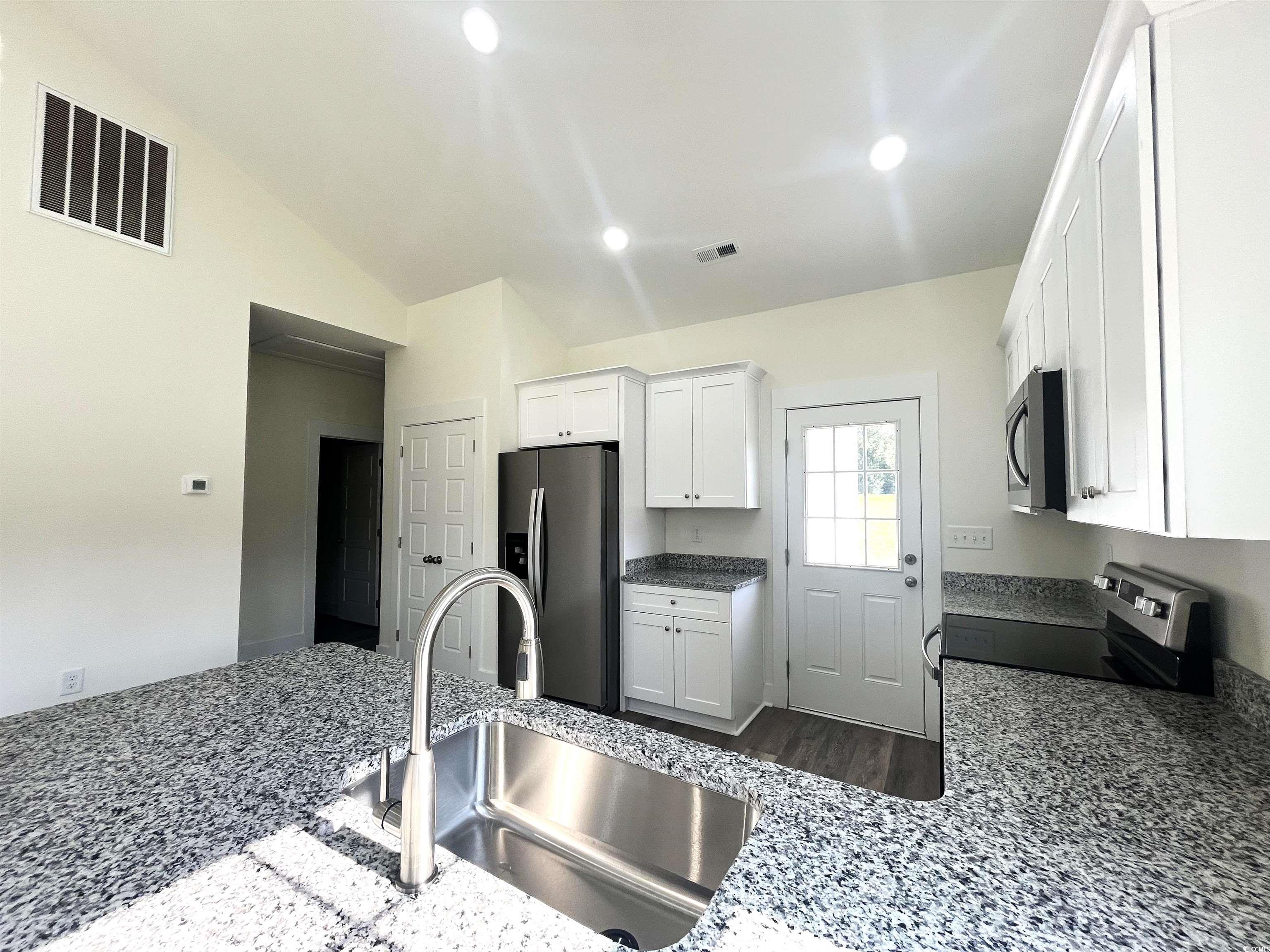 1174 St John Road Galivants Ferry, SC 29544 - Photo 9 of 22 Kitchen with appliances with stainless steel finishes, white cabinetry, recessed lighting, dark stone countertops, and dark wood-style flooring