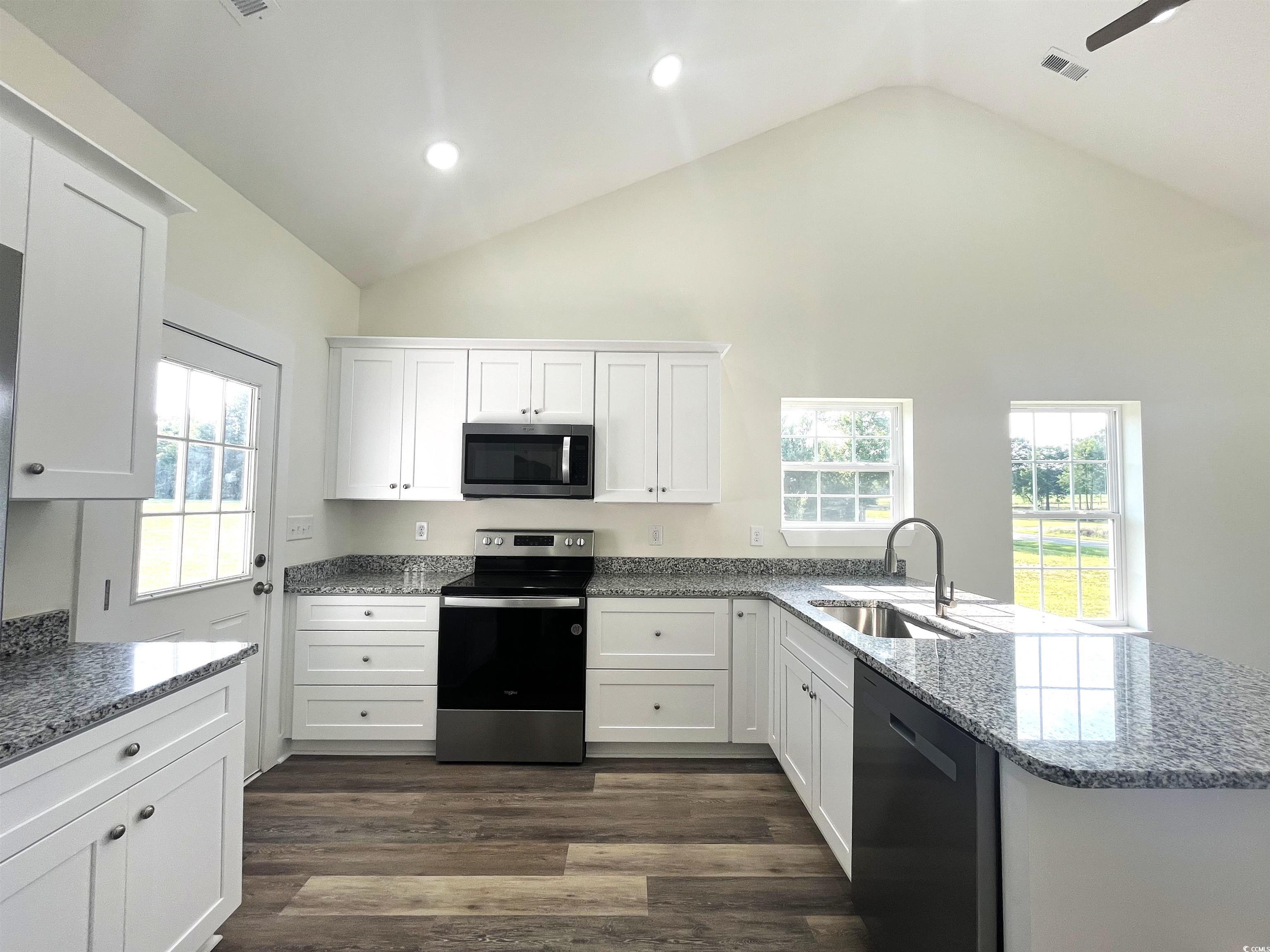 1174 St John Road Galivants Ferry, SC 29544 - Photo 10 of 22 Kitchen featuring appliances with stainless steel finishes, white cabinetry, a peninsula, dark wood-style flooring, and light stone counters