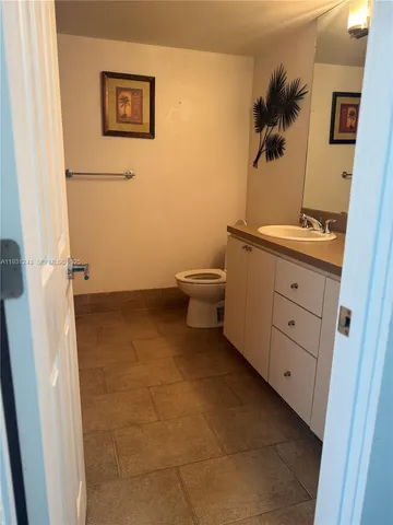 a bathroom with a granite countertop toilet and a sink