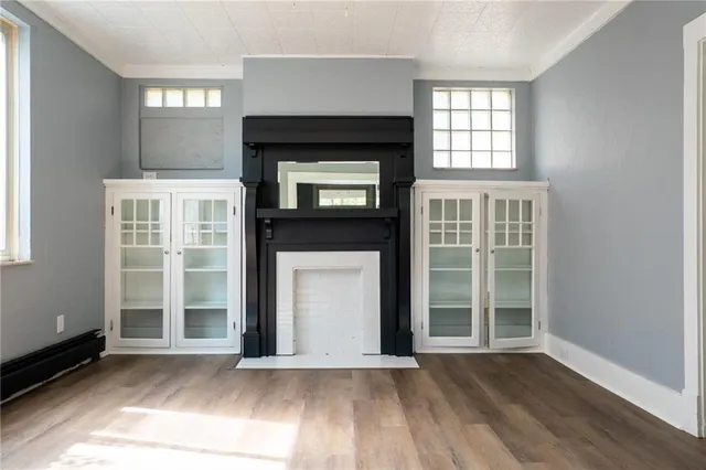 an empty room with windows and fireplace