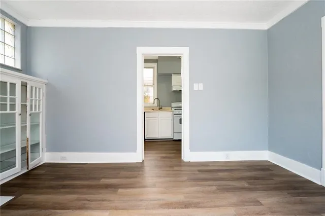 a view of a hallway with wooden floor and a bathroom