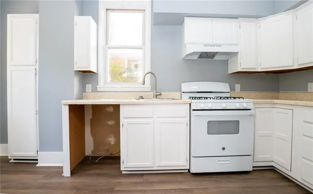 a kitchen with cabinets appliances a sink and a window