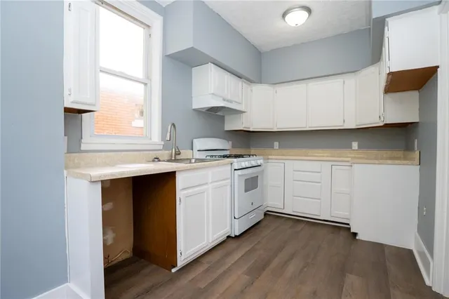 a kitchen with white cabinets and white appliances