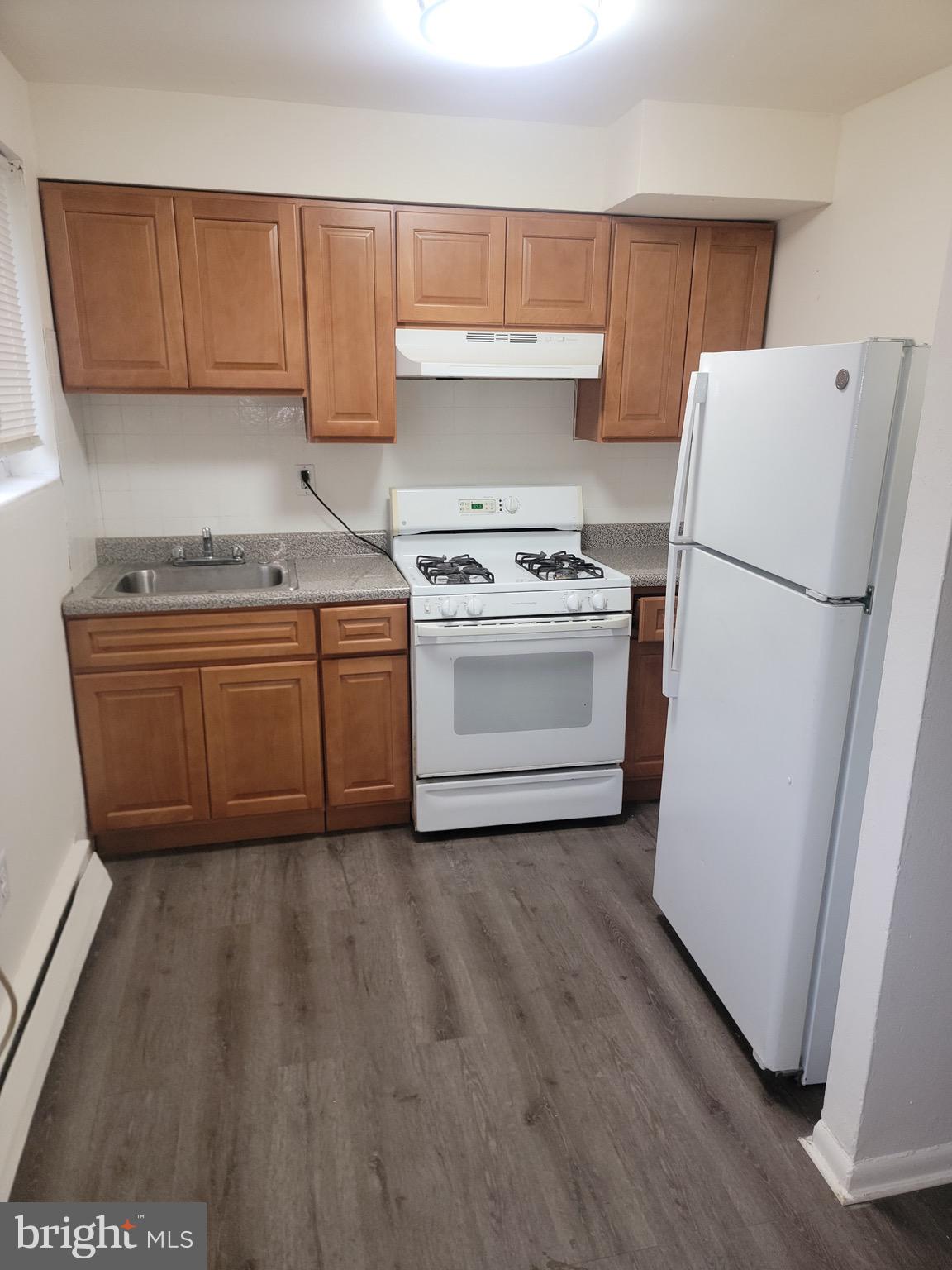a kitchen with a stove a refrigerator and a sink