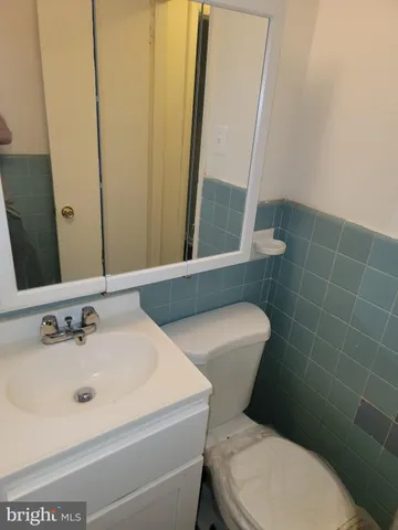 a bathroom with a toilet a sink and a mirror