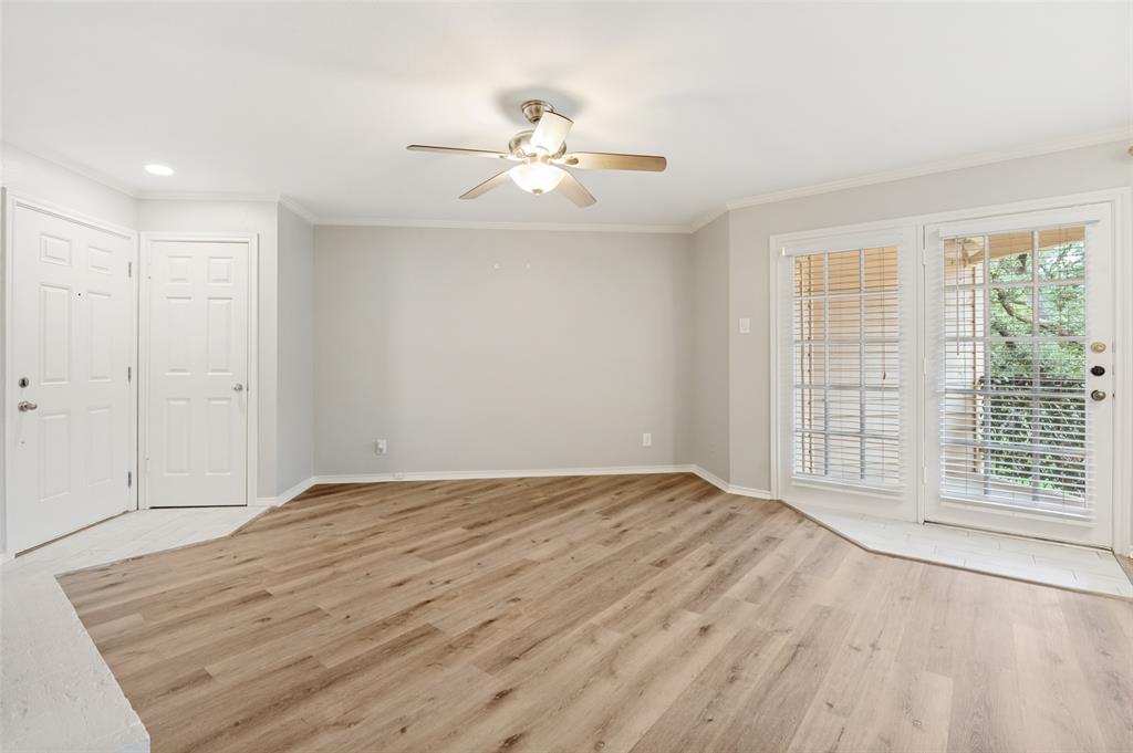 16301 Ledgemont Lane, Unit 263 Addison, TX 75001 - Photo 12 of 25 Spacious room featuring wood-finish flooring, light grey walls, white baseboards, and a ceiling fan with light fixture