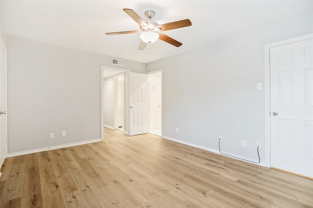 16301 Ledgemont Lane, Unit 263 Addison, TX 75001 - Photo 13 of 25 Spacious room featuring wood-finish flooring, light grey walls, white baseboards, and a ceiling fan with light fixture