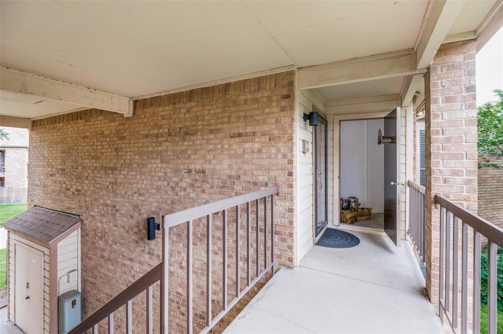 16301 Ledgemont Lane, Unit 263 Addison, TX 75001 - Photo 24 of 25 Entryway featuring a brick exterior, concrete flooring, and a dark brown metal railing
