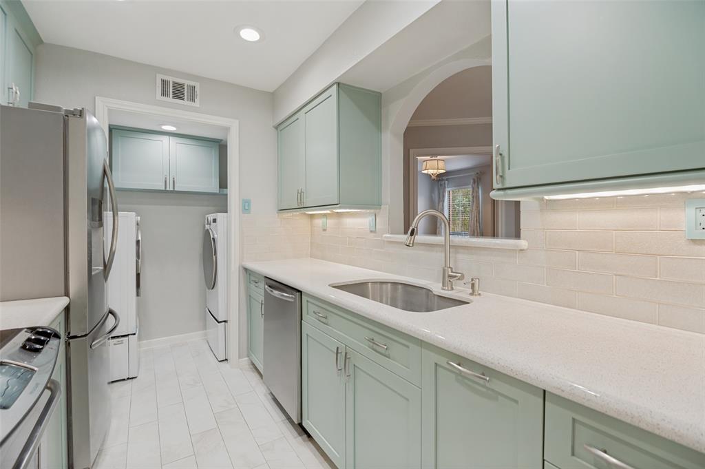 16301 Ledgemont Lane, Unit 263 Addison, TX 75001 - Photo 4 of 25 Kitchen featuring mint green cabinetry, light-toned countertops, stainless steel appliances, and a subway tile backsplash
