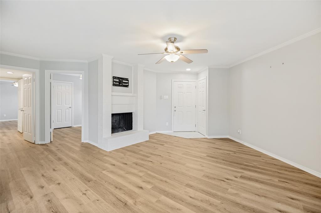 16301 Ledgemont Lane, Unit 263 Addison, TX 75001 - Photo 7 of 25 Spacious interior featuring wood-finish flooring, a wall of windows with blinds, and white trim