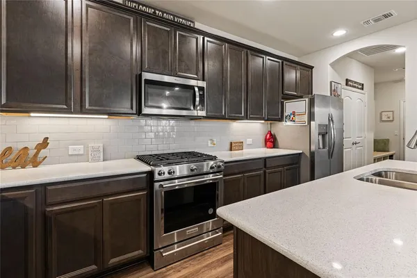 a kitchen with a sink stove and refrigerator