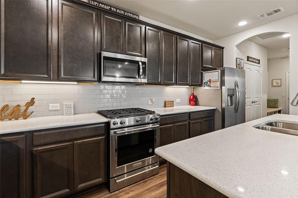 9517 Sunset Lane Oak Point, TX 75068 - Photo 15 of 40 a kitchen with a sink stove and refrigerator