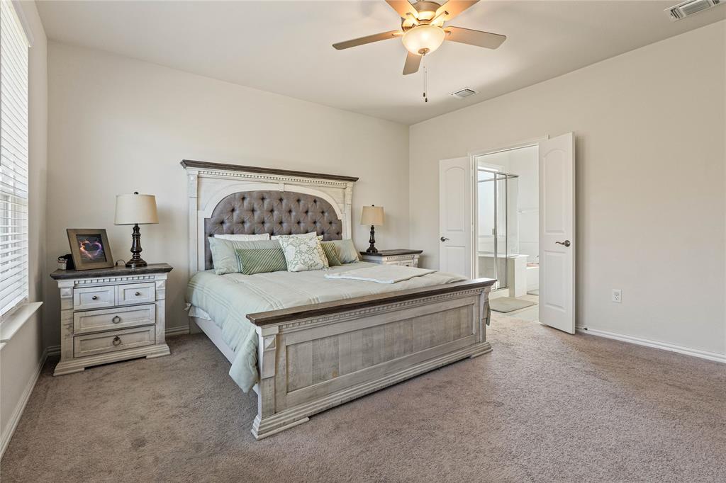 9517 Sunset Lane Oak Point, TX 75068 - Photo 20 of 40 a bedroom with a large bed and a chandelier