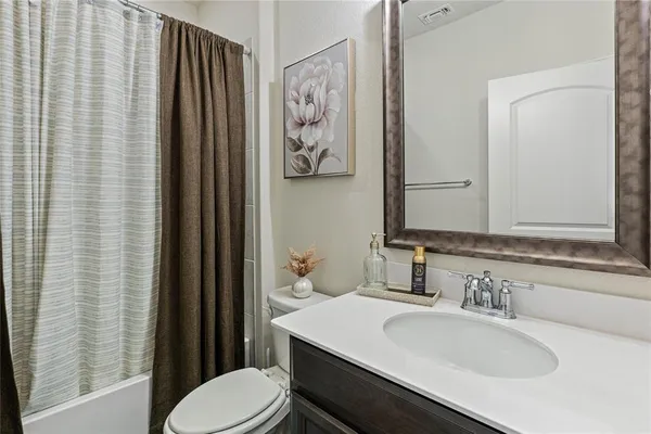 a bathroom with a sink vanity mirror and toilet