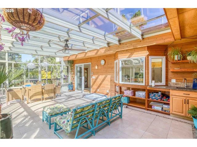a living room with a bed a table and chairs next to a window