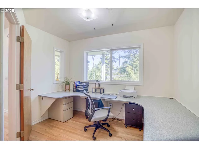 a view of a workspace with furniture and a window
