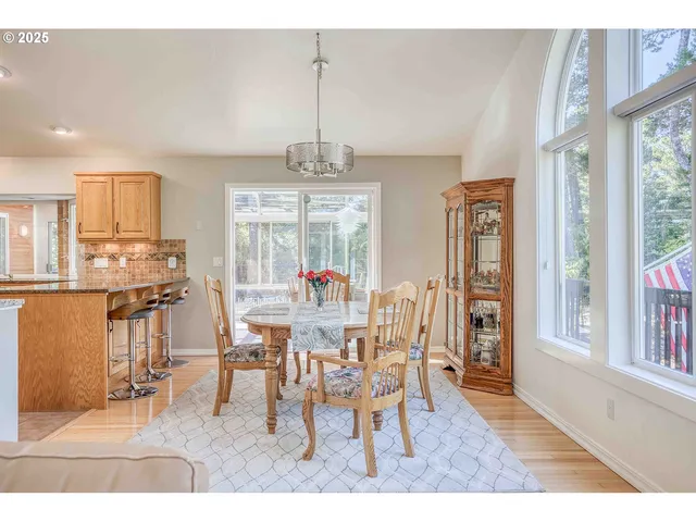 a dining room with furniture a chandelier and kitchen view