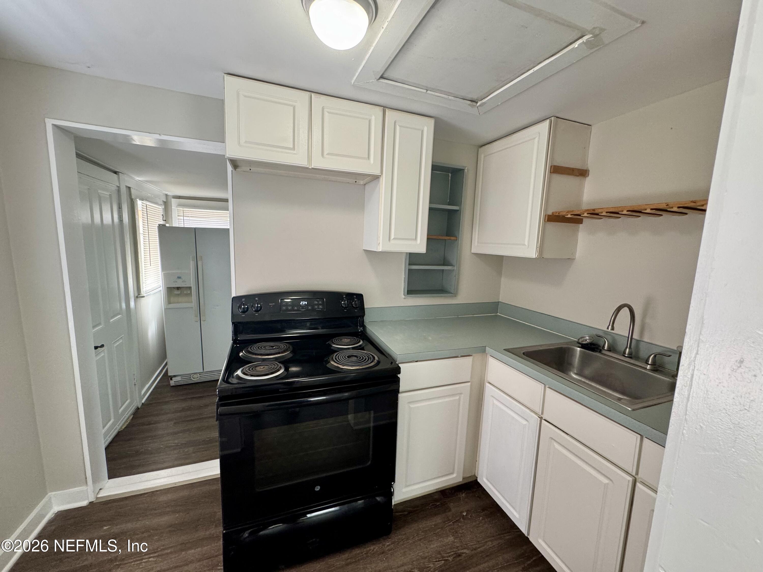 3673 Randall Street Jacksonville, FL 32205 - Photo 7 of 9 a kitchen with cabinets stainless steel appliances and wooden floor