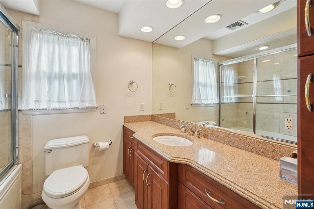 14 Valhalla Way Wayne, NJ 07470 - Photo 15 of 32 a bathroom with a granite countertop sink a toilet a mirror and shower
