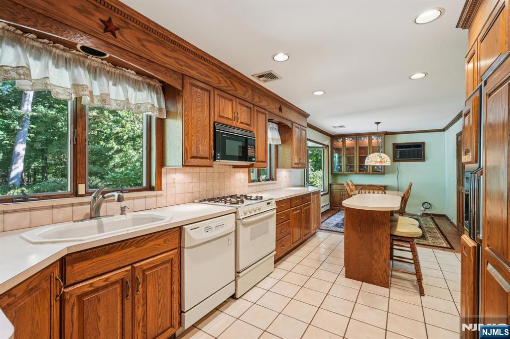 14 Valhalla Way Wayne, NJ 07470 - Photo 10 of 32 a kitchen with stainless steel appliances granite countertop sink stove top oven and cabinets