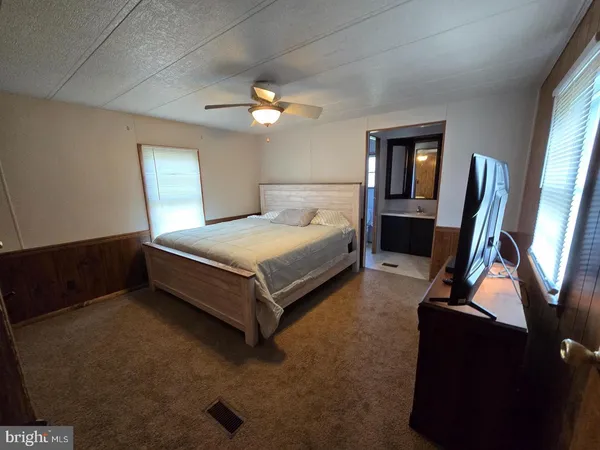 a spacious bedroom with a bed and a flat screen tv