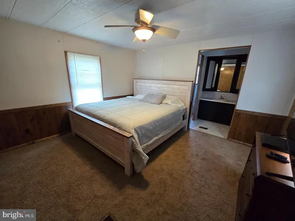 a spacious bedroom with a bed and a chandelier