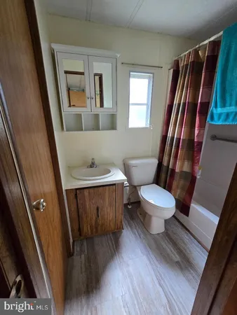 a bathroom with a toilet a sink a rug and a window