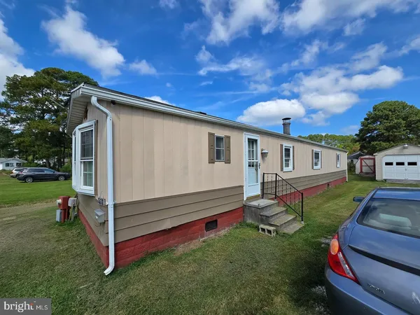 a backyard of a house with wooden fence and a large tree