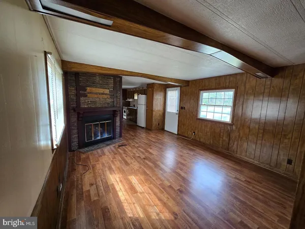 a view of a livingroom with wooden floor and a fireplace