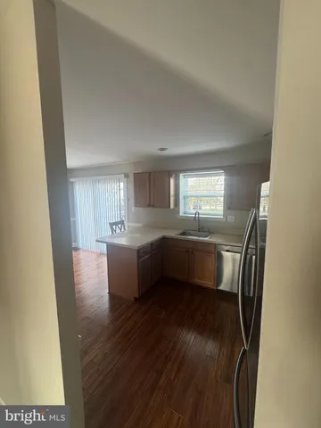 a view of kitchen and hall with wooden floor