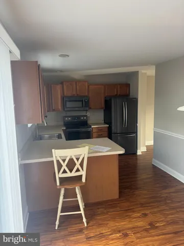 a kitchen with kitchen island a stove a refrigerator and a cabinets