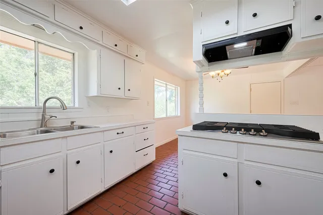 a kitchen with granite countertop white cabinets and white appliances