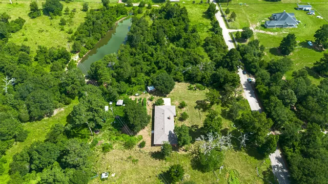 an aerial view of residential houses with outdoor space and trees