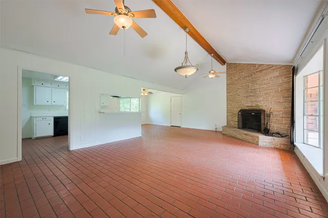 a view of empty room with wooden floor and fireplace