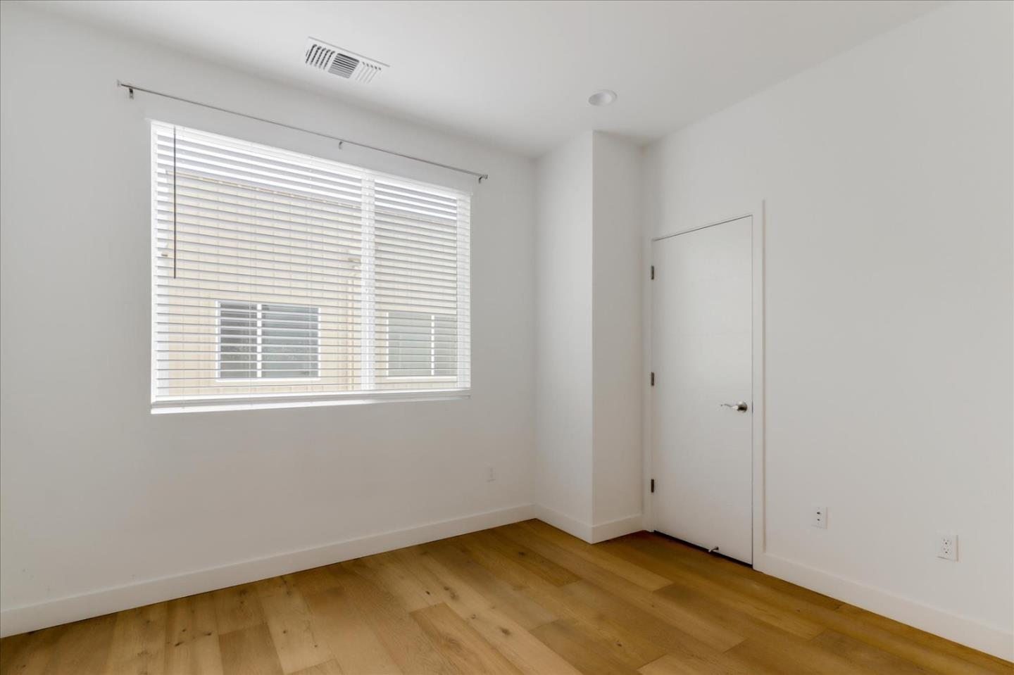 152 Uptown Circle Oakland, CA 94607 - Photo 21 of 33 a view of an empty room with wooden floor and a window